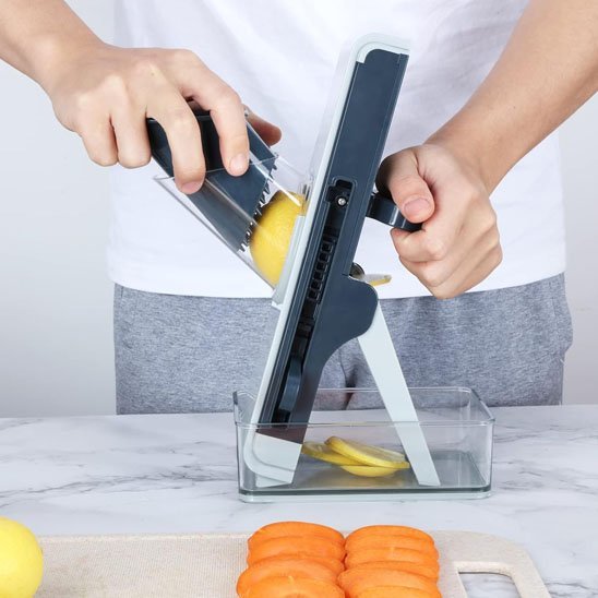 Homme tranche avec mandoline cuisine des pommes de terre