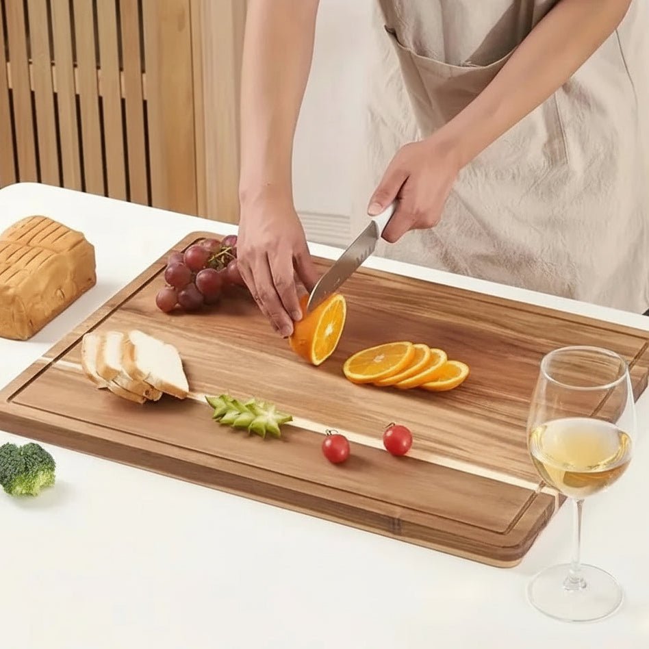 Femme coupe fruit sur planche bois à découper