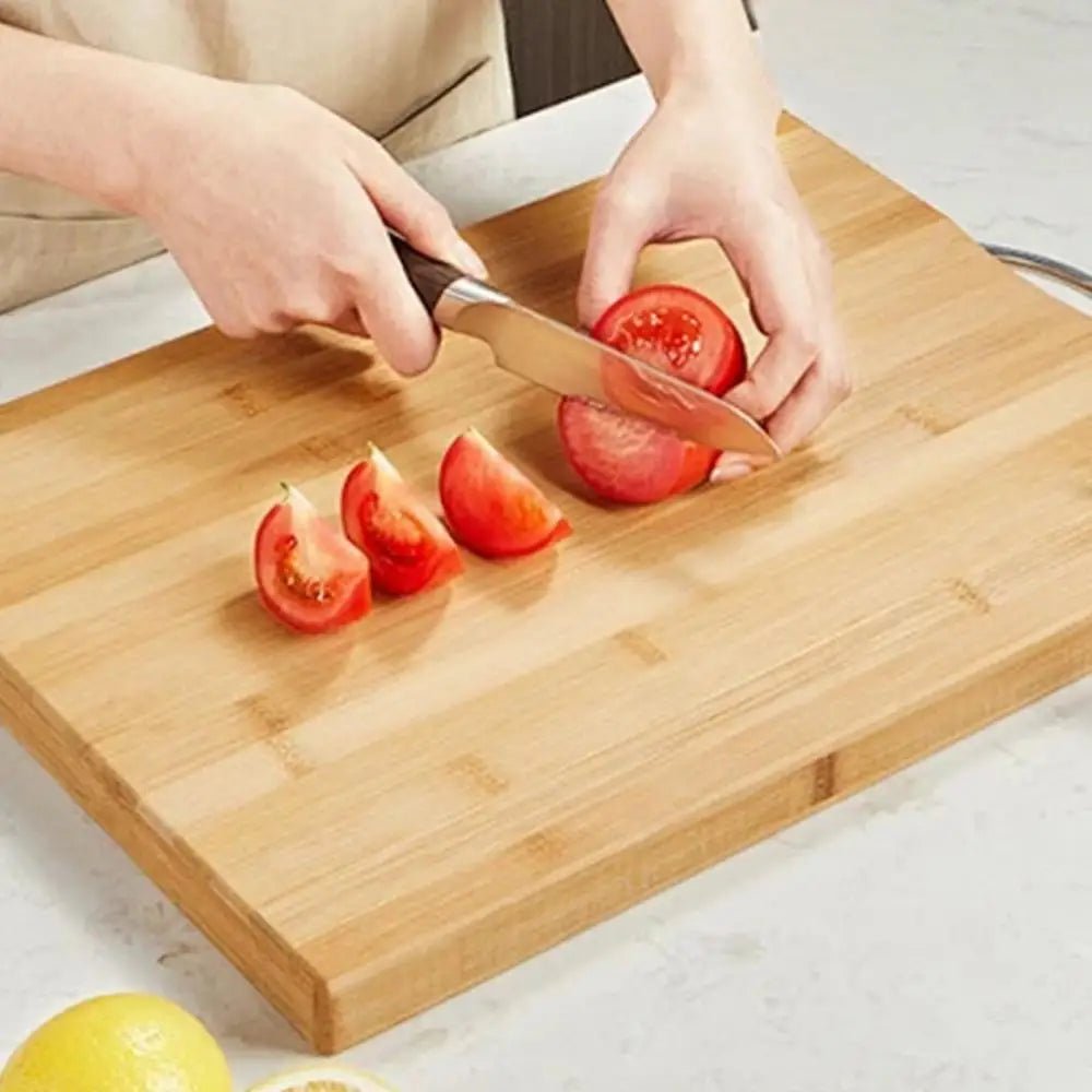 Femme tranche tomate sur planche en bois à découper