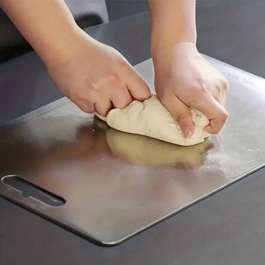 boulanger manipule pâte sur planche à découper en inox