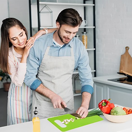 Couple prépare repas sur planche a decouper