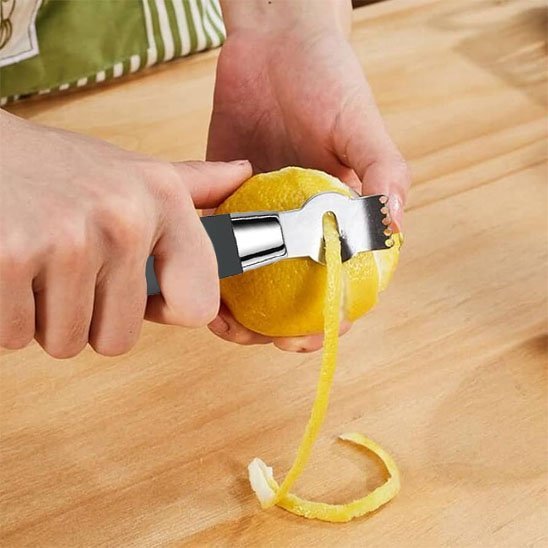 Cuisinière zeste en spirale un citron avec un Zesteur citron