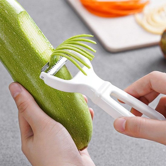 Econome qui fait des juliennes de courgette