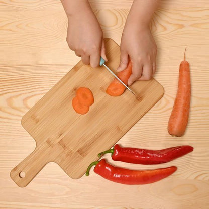 Enfant coupe légumes sur planche en bois a decouper 