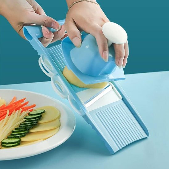 Femme tranche patates sur mandoline cuisine 