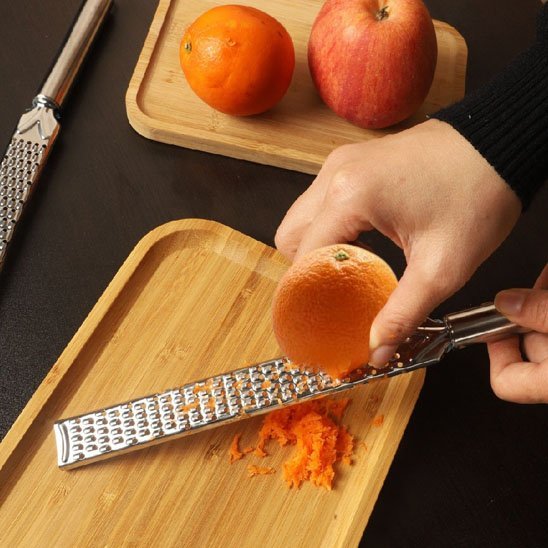 Femme zeste orange sur Rape microplane 