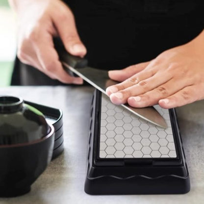 homme affûte lame sur Aiguiseur de couteaux