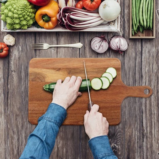 homme coupe légume sur Planche à découper en bois