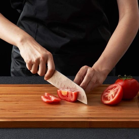 Homme coupe légumes sur planche à découper en bois