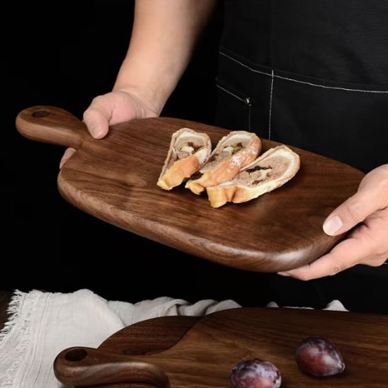 Homme transporte pain sur planche bois à découper en noyer