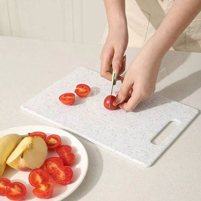 femme coupe tomates sur planche a decouper blanche