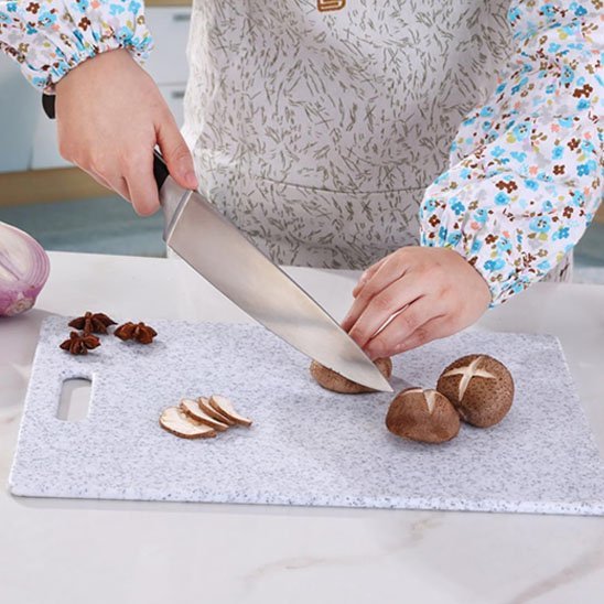 Enfant tranche des champignons sur planche a decouper blanche