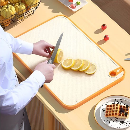  Chef tranche un citron sur planche a decouper en bioplastique